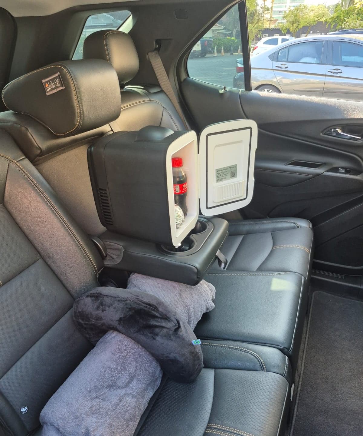 Banco traseiro de couro da Chevrolet Equinox com frigobar aberto, manta e travesseiro de viagem.